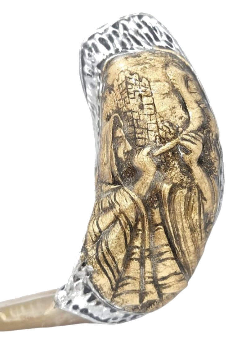 Close-up of gold-tone priest blowing shofar relief at the Western Wall on a ram horn shofar