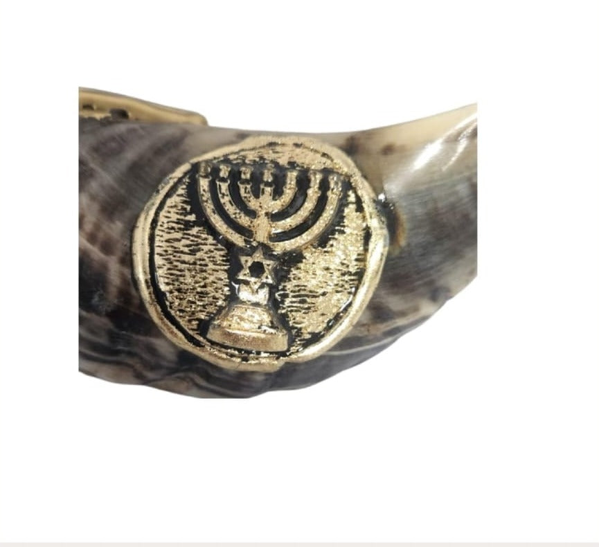 Close-up of the gold-tone menorah emblem on a natural ram's horn